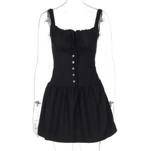 Close-up of black mini dress with ruched chest, decorative buttons, and front tie details