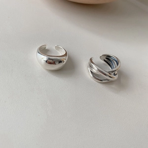 Detail of silver drop ring and intertwined lines with polished mirror finish surface