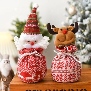 Detail of knitted Christmas drawstring gift bags featuring Santa and reindeer cartoon designs
