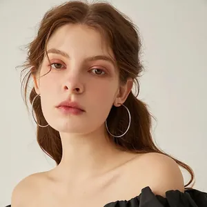 Polished 2mm stainless steel large hoop earrings for women worn by a model