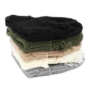 Close-up of five distressed knit beanies in black, green, khaki, cream, and grey colors