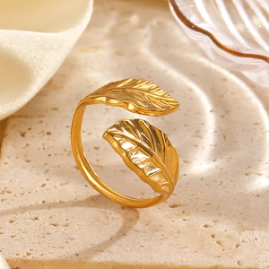 Elegant gold leaf open ring featuring detailed textures on a travertine stone surface
