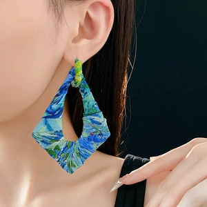 Detailaufnahme handgefertigter floraler Stoffohrringe in Blaugrün in Rautenform am Model