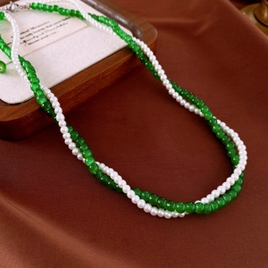 Detail of double-layer necklace with emerald green beads and small round pearls