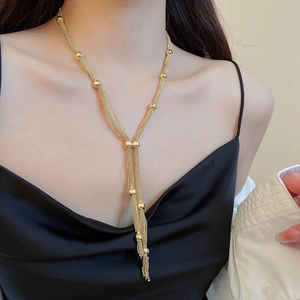 Detail shot of multi-layered gold tassel necklace with beads on model for fashion display