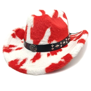 Macro shot of red cow print cowboy hat featuring skull metal badge and studded band