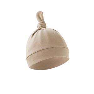 Newborn baby knot hat in light beige soft knit fabric with a top tail design
