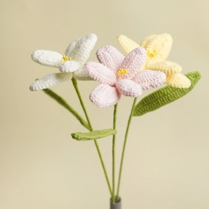 Handmade crochet tulip flower bouquet in white pink and yellow colors with a grey vase