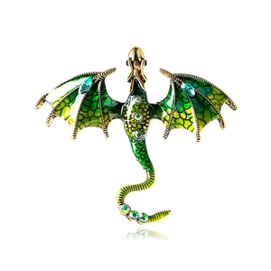 Close-up of green enamel dragon brooch with crystal scales and golden metal base