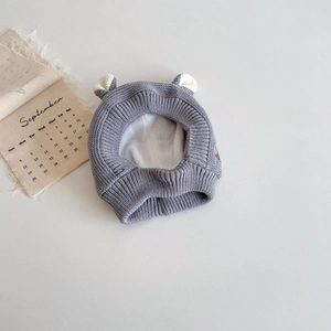 Détail du bonnet tricoté gris pour bébé avec oreilles d'ours et doublure polaire chaude