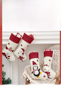 Detail of four rustic Christmas stockings featuring reindeer and santa on a mantelpiece