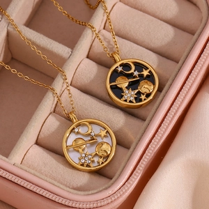 Detail of celestial necklaces with star and moon pendants in a pink jewelry box