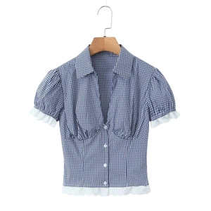 Close-up of blue gingham shirt featuring delicate white lace trim and button detail