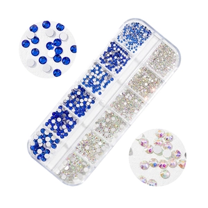 Detailed macro view of 12-grid box containing blue and AB crystal flatback nail art rhinestones