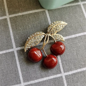 Broche cerise rouge émaillée avec feuilles dorées étincelantes et strass pour femme