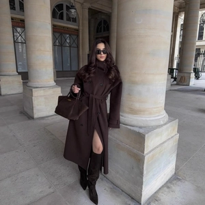 Trench lungo doppiopetto marrone scuro con cintura e stivali coordinati eleganti
