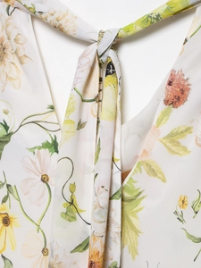 Detail view of the floral print neckline with bow tie on a cream summer dress