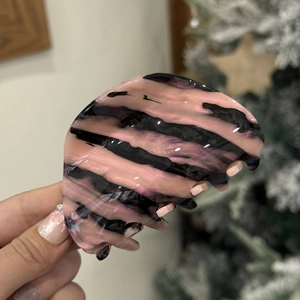 Close-up of pink and black zebra pattern acetate hair claw clip with glossy resin finish
