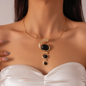 Detail of gold spiral collar necklace featuring three cascading black resin oval stones