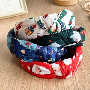 Set of four Christmas knotted headbands with Santa Claus and festive prints on wood surface
