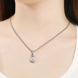 Détail du collier en acier titane argenté avec pendentif relief ovale sur le cou