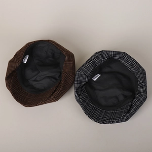 Detail view of the inner lining and size label of the plaid newsboy hat with neat stitching