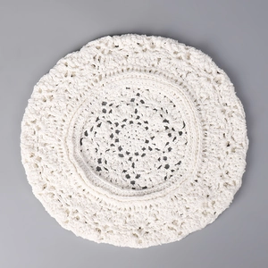 Nahaufnahme der weißen Häkel-Baskenmütze mit filigranen Blumenstrickmustern