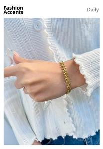 Close-up of golden X-link chain bracelet on wrist showing texture and elegant style