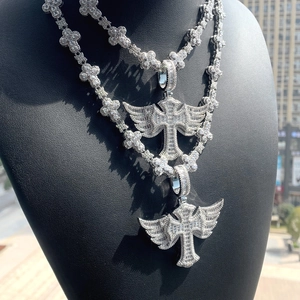 Macro detail of iced-out silver cross pendant with wings on a hip-hop tennis chain