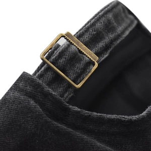 Close-up of adjustable metal buckle and stitching on black washed denim baseball cap