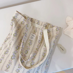 Macro view of floral canvas tote bag with purple flower patterns and inner fabric label