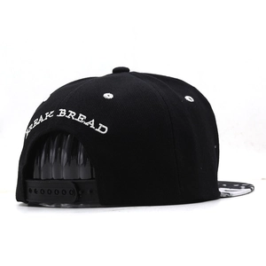 Black snapback baseball cap featuring BREAK BREAD embroidery and adjustable back closure