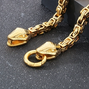 Macro detail of gold double snake heads with intricate Byzantine chain texture