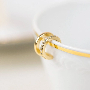 Detailed macro shot of 18k gold plated double hoop ear cuff with shimmering zircon inlay
