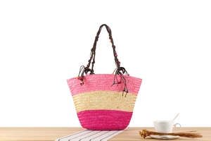 Détail d'un sac cabas bohème tricolore en paille avec coutures roses et perles en bois
