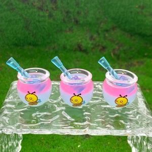 Macro view of three pink and white miniature honey jars with blue stirrers on glass