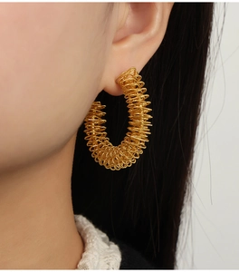 Vue latérale d'un mannequin portant une boucle d'oreille créole torsadée en or