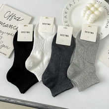 Flat lay of cotton candy color low cut socks in black, white and grey with heel tabs