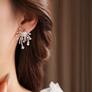 Detail of 18K gold plated fireworks stud earring with pearls on a model ear
