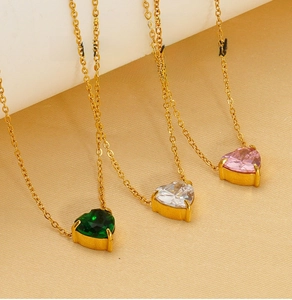Close-up of gold-plated stainless steel heart necklaces in green, white, and pink zircon
