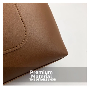 Close-up of brown textured leather with detailed stitching on a commuter tote bag