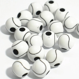 Macro shot of white acrylic sports beads for jewelry making showing soccer ball details