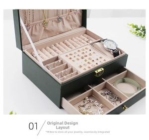 Detailed view of dual-layer dark green leather jewelry box with pink velvet lining