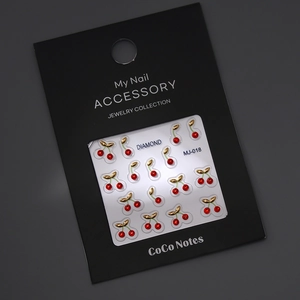 Close-up of MJ-018 red cherry nail charms with gold leaves and K9 crystals on display card