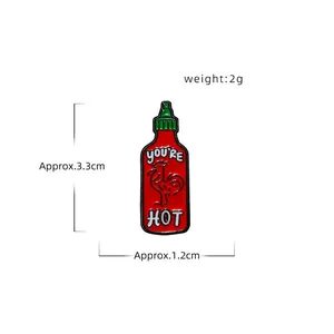 Cartoon chili sauce enamel pin with rooster logo and You're Hot text on white background