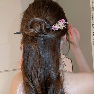 Classic wooden hair pin with pink flowers and tassels shown in a traditional hairstyle