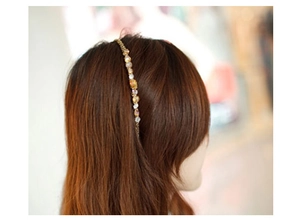 Detail of amber and gold beaded headband on hair with metallic chain accents
