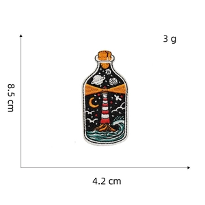 Detailed embroidery patch showing a lighthouse in a bottle with size 8.5cm by 4.2cm