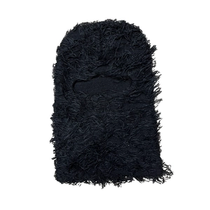 Close-up of black distressed knit balaclava with long fringe tassels and eye opening