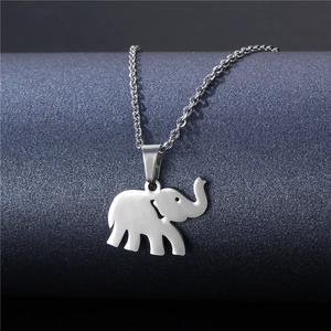 Minimalist silver elephant pendant necklace in stainless steel shown on a textured display